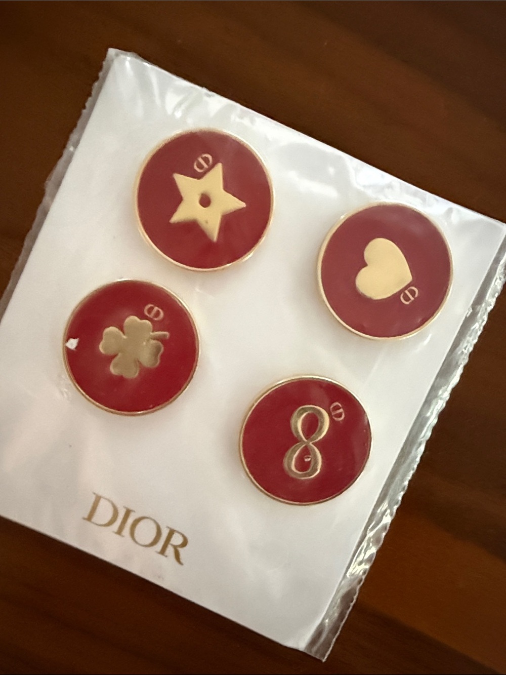 A set of four limited-edition Christian Dior red and gold pins
